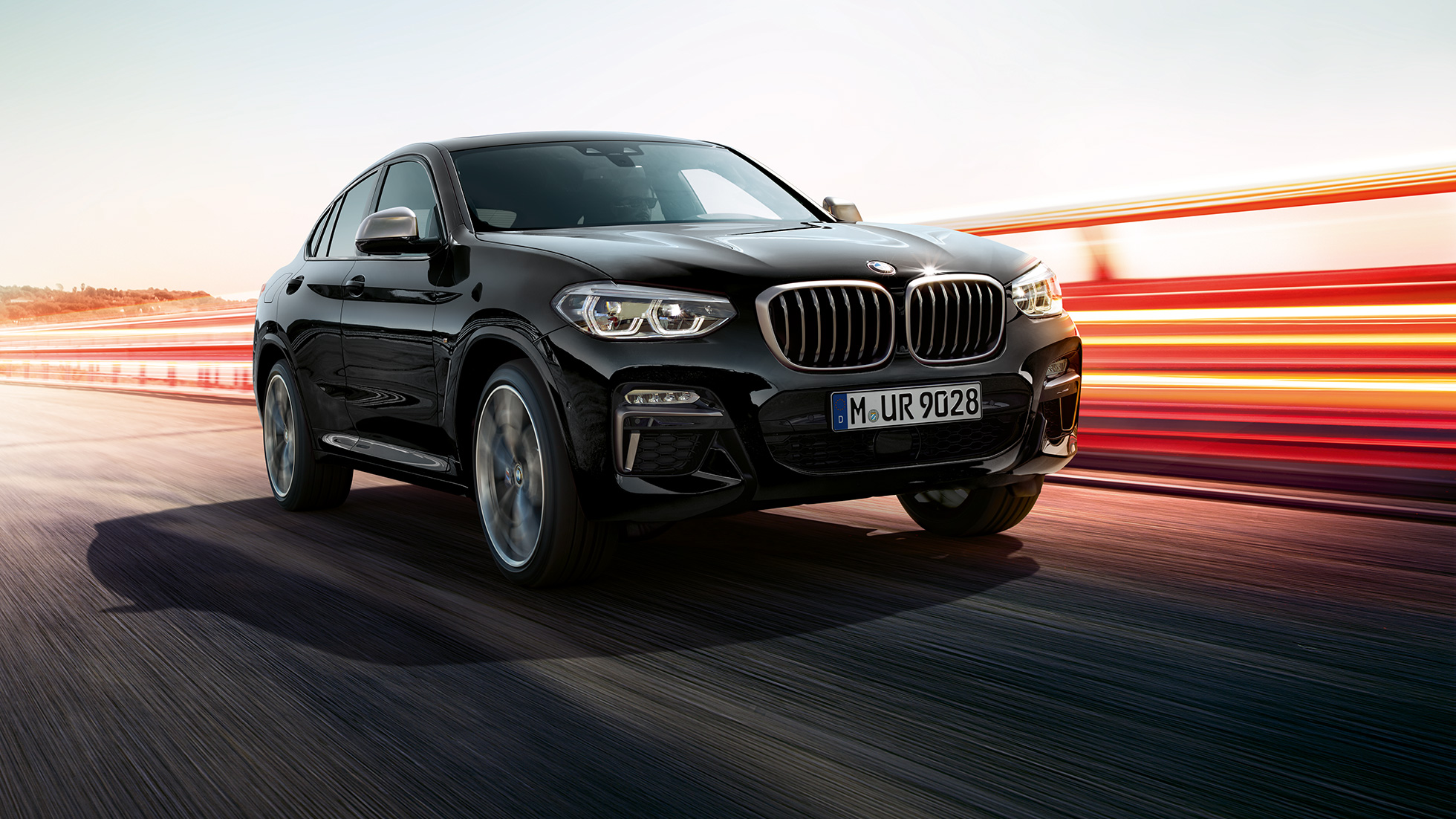 BMW X4 M40i、斜めフロント・ビュー。F98 ブラック・サファイア・メタリックのBMW X4 M40i、エクステリア、斜めフロント・ビュー、ライト・ストリップの見える左側面。F98