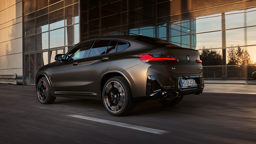 BMW X4 M40i G02 LCI 2021フェイスリフト 斜めからのリヤ・ビュー ガラス・ファサードを背景にして