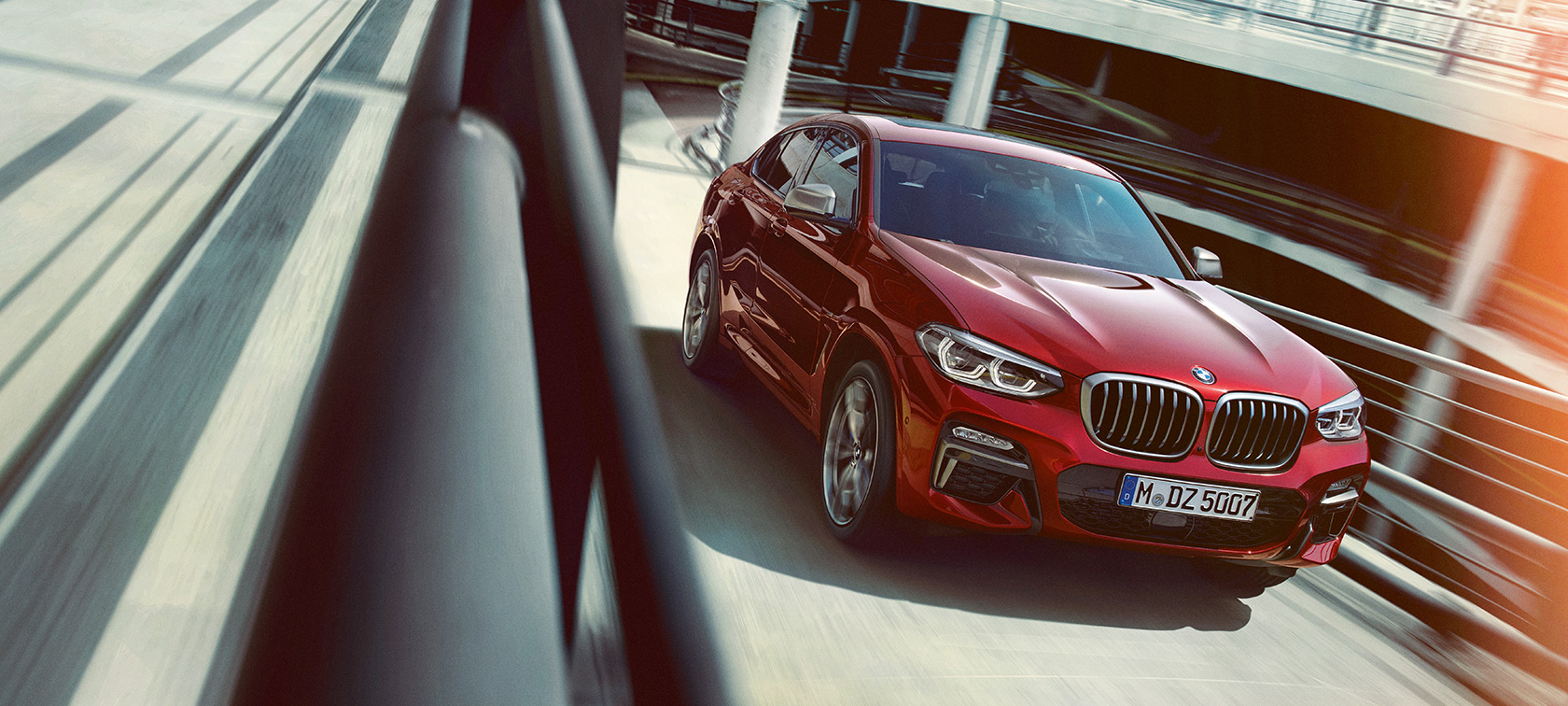 BMW X4 立体駐車場走行中 BMW X4 G02 2018 フラメンコ・レッド・ブリリアント・エフェクト 斜めからのサイド・ビュー 立体駐車場走行中