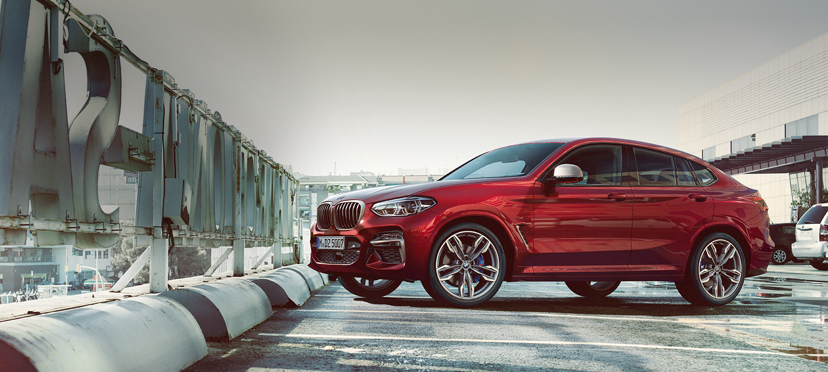 パーキングでのサイド・ビューBMW X4 BMW X4 M40i G02 2018 フラメンコ・レッド・ブリリアント・エフェクト サイド・ビュー 屋上駐車場に駐車している