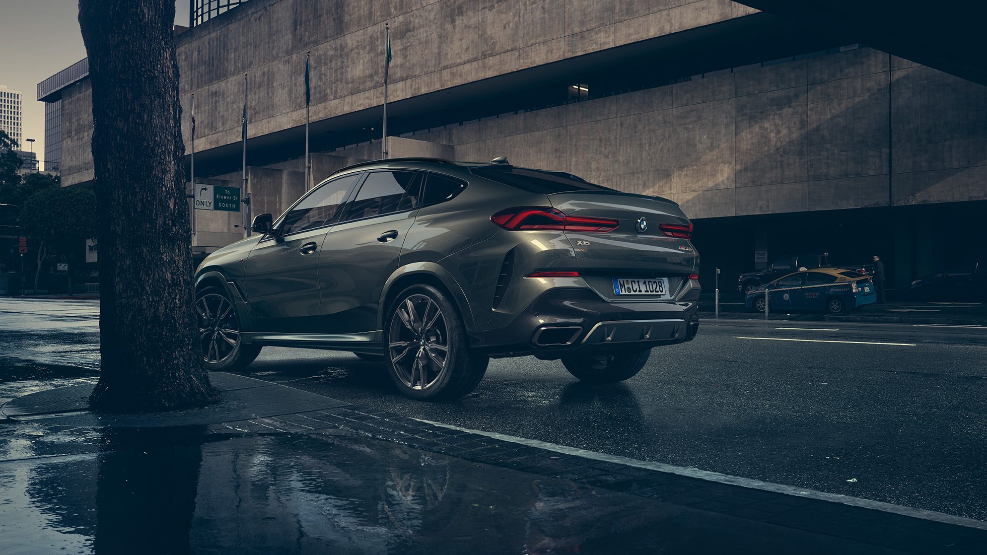 BMW X6のエクステリア。G06 BMW X6リアのスリークォータービュー、ある都市風景を背景に。G06