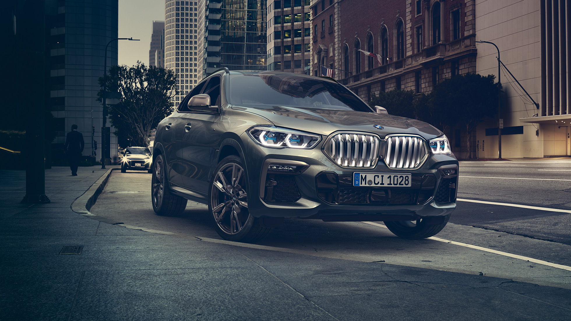 BMW X6 アダプティブ M サスペンション プロフェッショナル G06 BMW X6フロントスリークォータービュー。ある都市風景を背景に。G06