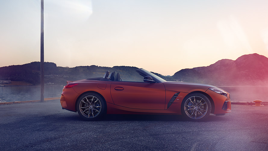 曲がり角にある オレンジのBMW Z4 First Edition 山を背景にした曲がり角にあるオレンジの BMW Z4 First Edition
