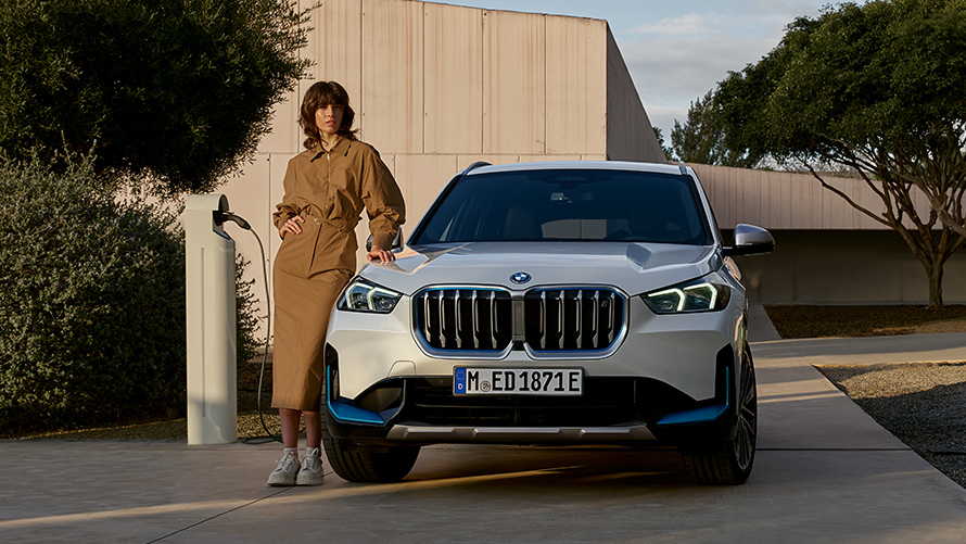 BMW iX3 BMW iX3 G08 2021の前にいる緑の上着を着た男性 BMW iX3 G08 2021の前にいる緑の上着を着た男性 サイド・ビュー