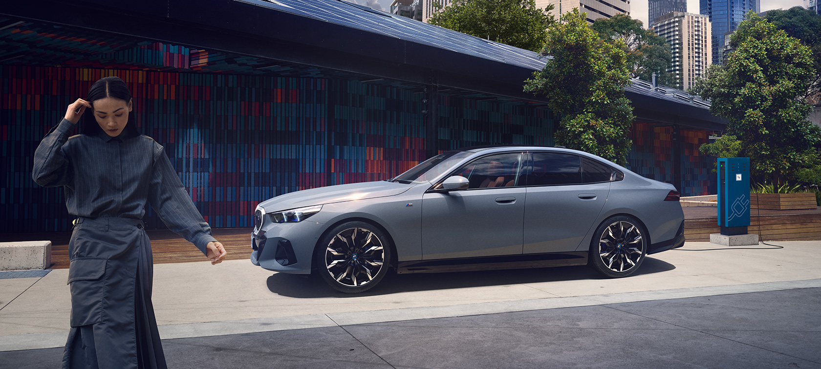 BMW i5 G60 充電中の女性 サイド・ビュー BMW i5 G60 充電中の女性 サイド・ビュー