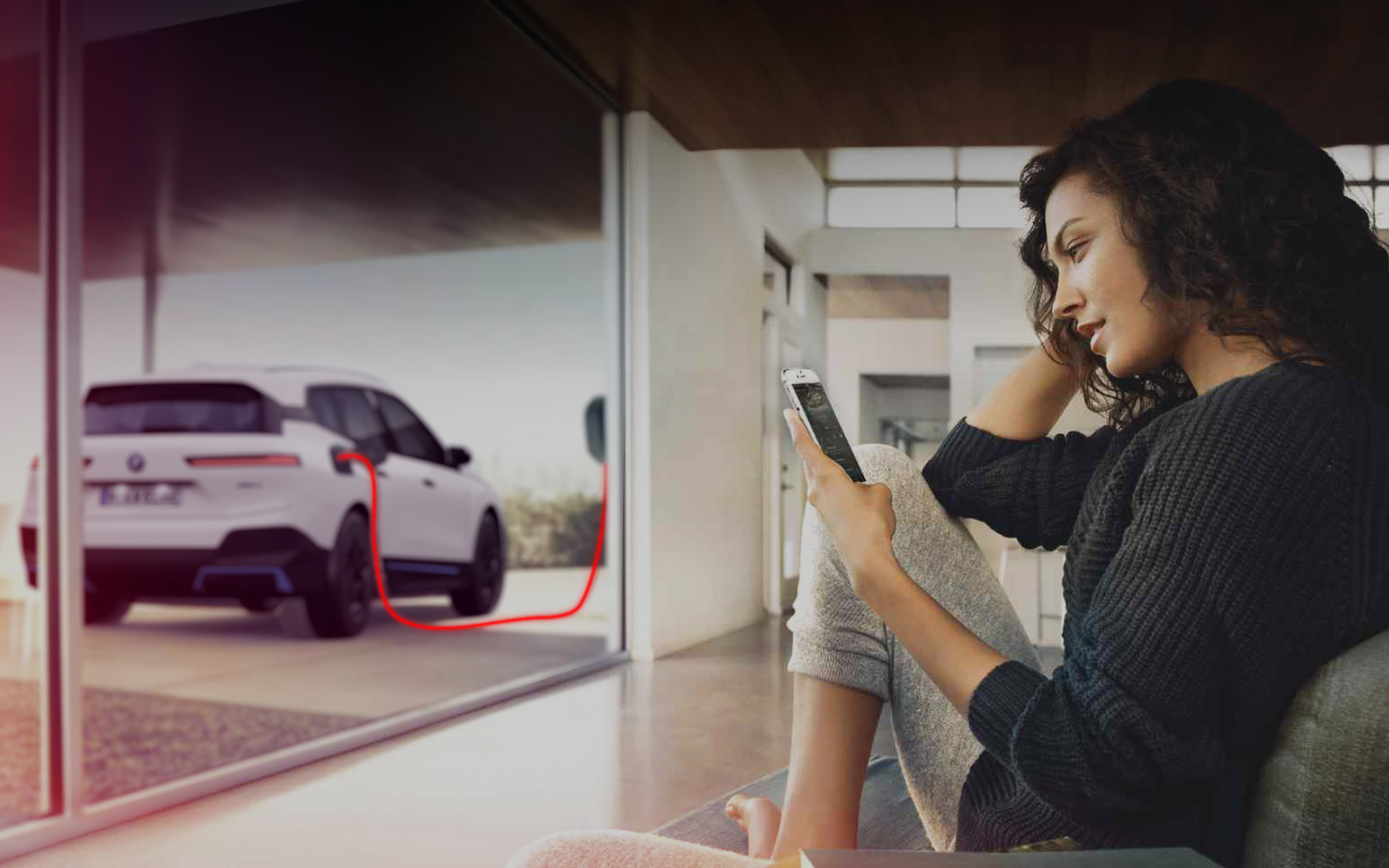 自宅での充電 BMW iX i20 スマートフォンを持つ女性