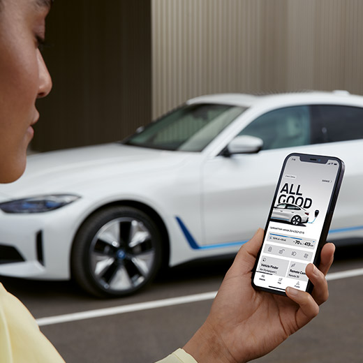 BMW i4 G26を背にMy BMW アプリの Connected Chargingを利用する女性 BMW i4 G26を背にMy BMW アプリの Connected Chargingを利用する女性