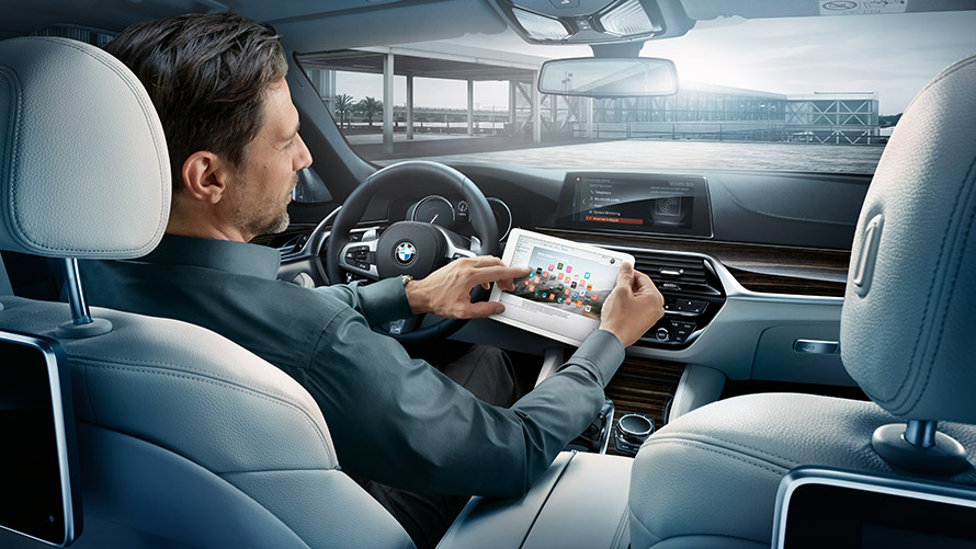 Wi-Fi Hotspot Man in BMW and woman outside the BMW using Wi-Fi Hotspot on smartphone
