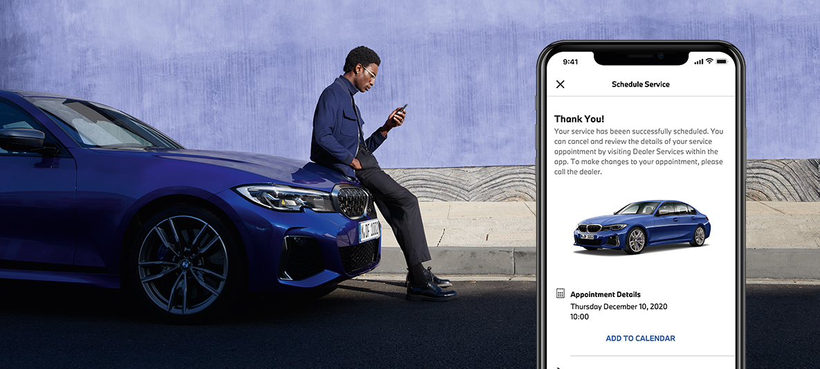 My BMW Appでサービス体験を管理 BMWのボンネットに座っている男性 My BMW Appでサービス体験を管理 BMWのボンネットに座っている男性