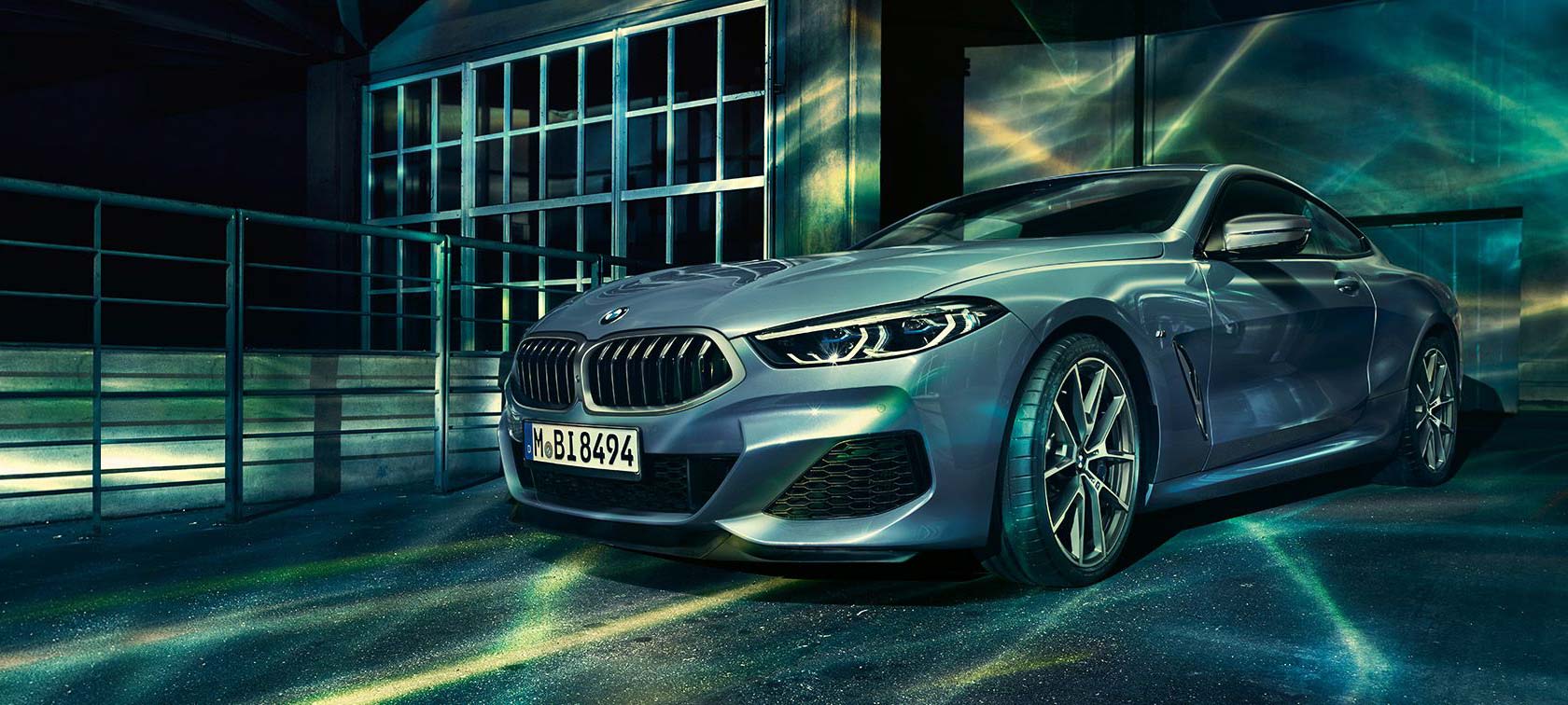 BMW 8シリーズ クーペ、斜めからのフロント・ショット。 BMW 8シリーズ クーペ、斜めからのフロント・ショット、産業施設を背景に。