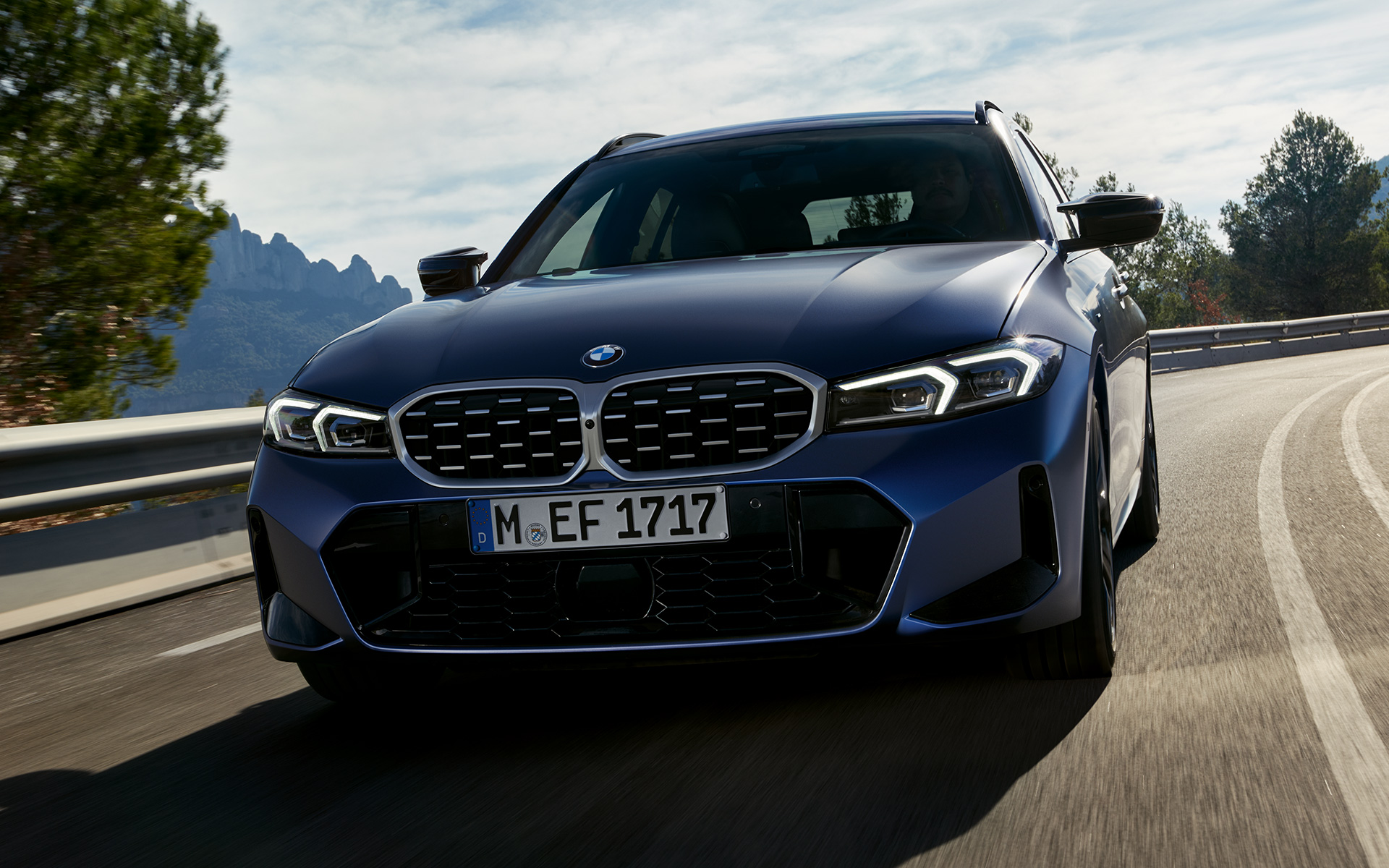 BMW M340i xDrive ツーリング G21 フローズン・タンザナイト・ブルー フロント・ビュー 路上を走行中