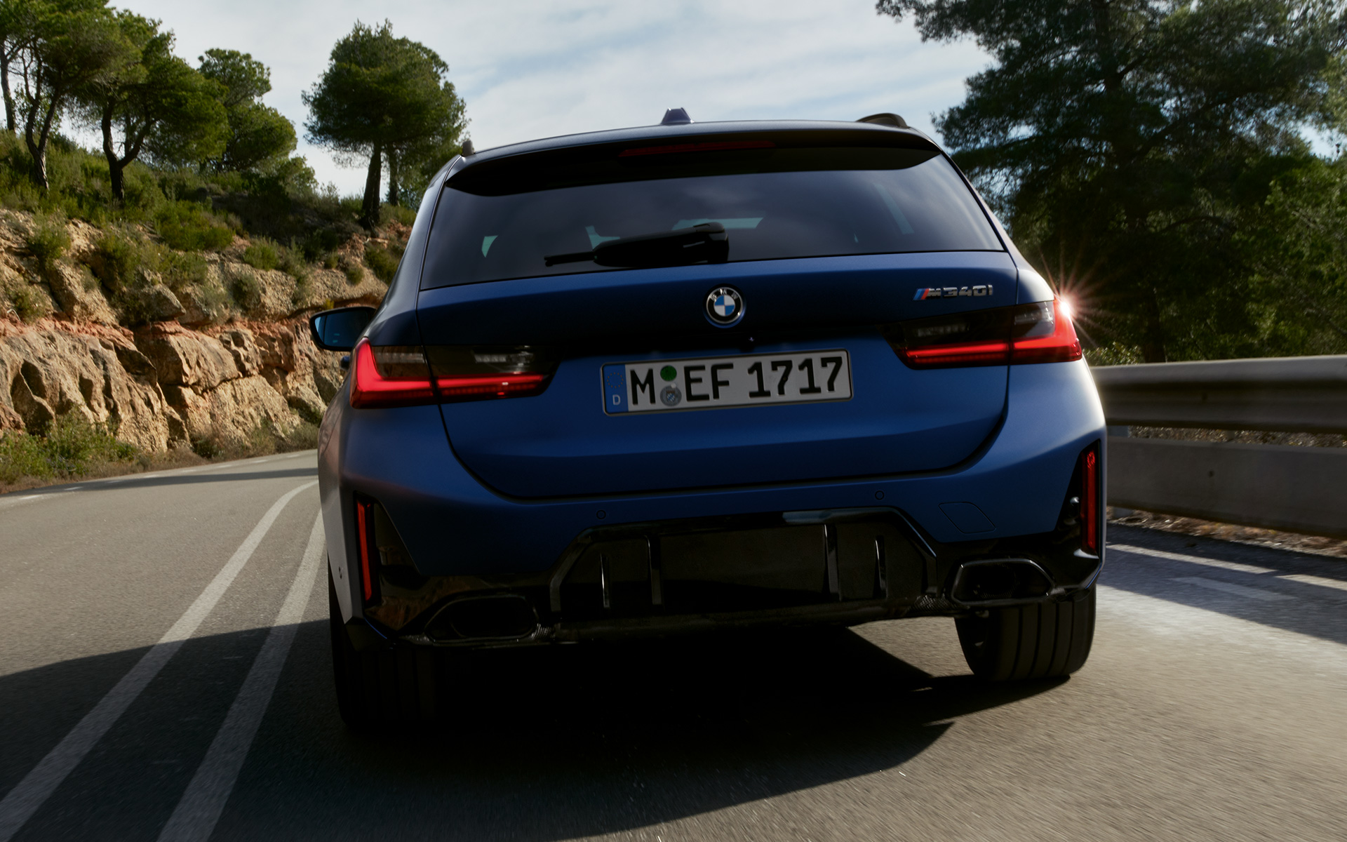 BMW M340i xDrive ツーリング G21 フローズン・タンザナイト・ブルー リヤ・ビュー 路上を走行中