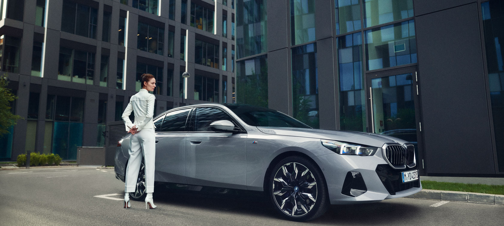 BMW three-quarter front view in front of mountain landscape with woman and man BMW Financial Services three-quarter front view in front of mountain landscape with woman and man